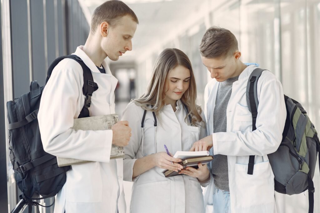 Tres estudiantes de medicina revisan sus notas en un pasillo.