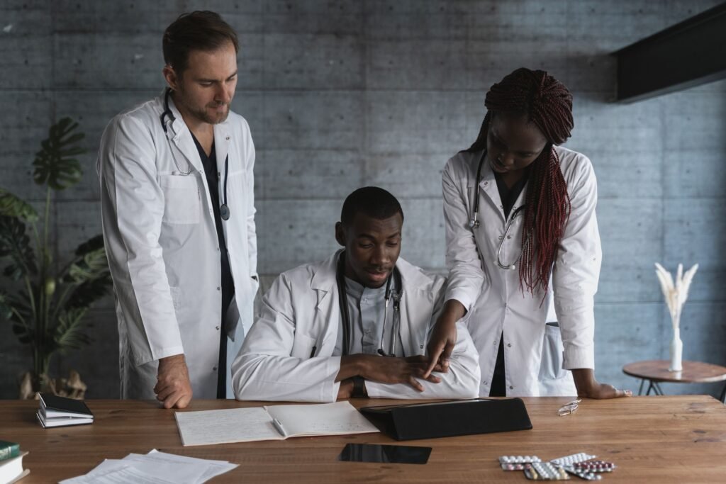 Profesionales de medicina revisan documentos y una tableta.
