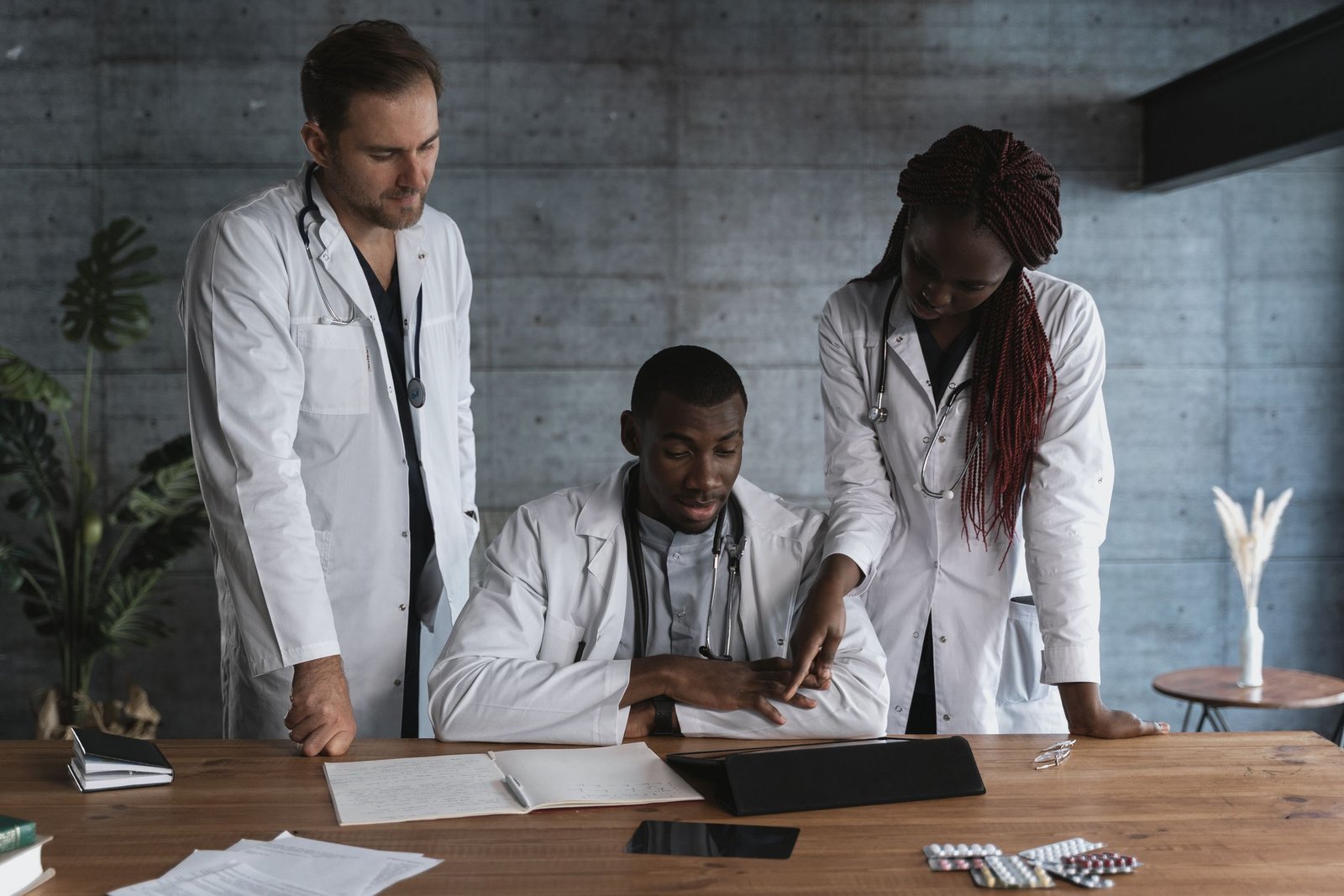 Profesionales de medicina revisan documentos y una tableta.
